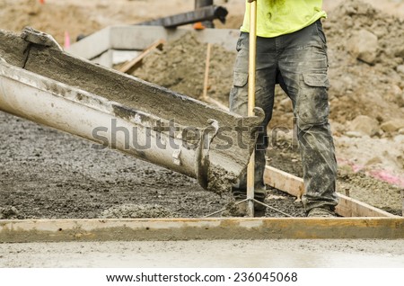 Concrete construction contractor installing a sidewalk, curb and storm drainage gutter on a new urban road street project