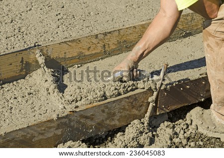 Concrete construction contractor installing a sidewalk, curb and storm drainage gutter on a new urban road street project