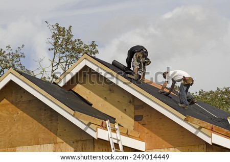 Construction crew working on the roof sheeting of a new, luxury residential home project in Oregon