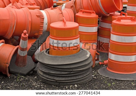 Stack of road repair construction orange pylon and barrels