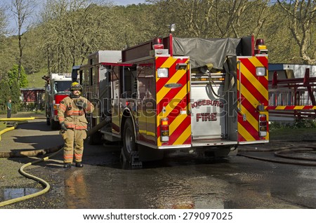 Roseburg OR, USA - March 26, 2014: Fire engine and pump operator engineer on a structure fire of a mobile home