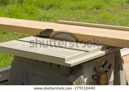 Wood siding contractor using a table saw to cut window and door trim boards on the construction of a new home