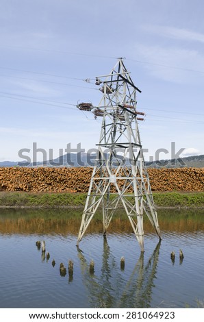 Large high tension metal electrical tower in a log pond at a lumber mill in the Columbia River Gorge
