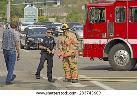Roseburg, OR, USA - April 2, 2015: Firefighters respond to a two vehicle accident with on car on fire.