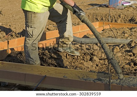 Concrete contractor using a concrete pump to fill the foundation of a custom luxury home
