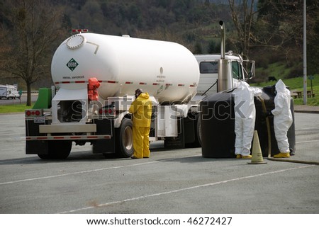 Haz mat workers containing a small leak in the fill hose of an ammonia bobtail tank truck.