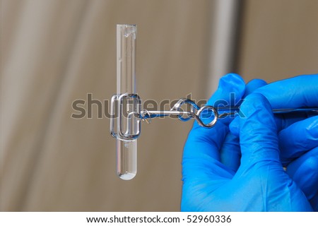 Test tubes and kit for testing and identifying hazardous materials. Person  with gloves testing a product