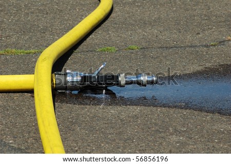 A large straight steam nozzle attached to a 3 inch hose for exposure protection at a structure fire.