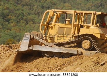 Excavator with a hydraulic rock breaker taking down a small hill for a new business development in Roseburg OR
