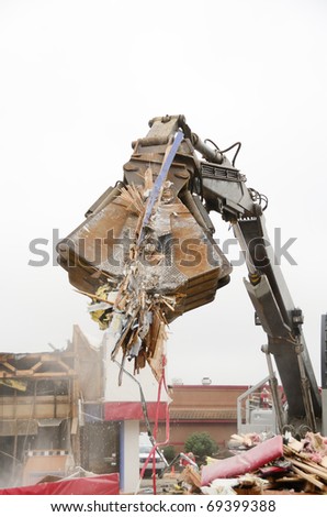 Large clamshell bucketed track hoe tearing down a former restaurant for a new commercial building project in Roseburg OR