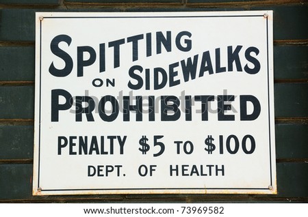 Spitting on Sidewalks prohibited sign on a brick wall
