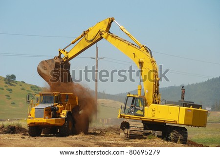 Large excavator loading a large dump truck at a new freeway interchange project near Roseburg Oregon