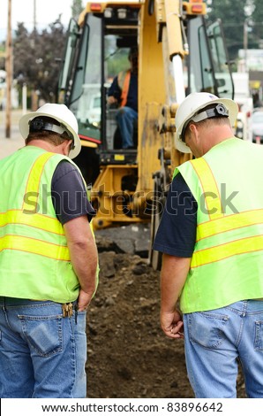 Public works supervisors at a excavation hole to repair a 12 inch water main failure on Harvard Ave in Roseburg OR
