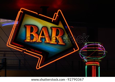 Bar sign arrow showing the way in a nightclub area.