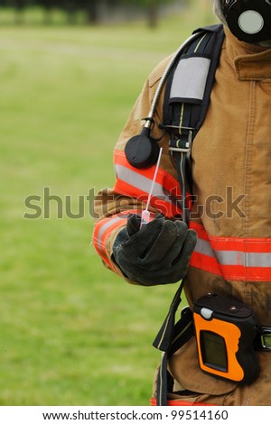 A firefighter taking a sample of a liquid chemical at a hazardous materials incident.