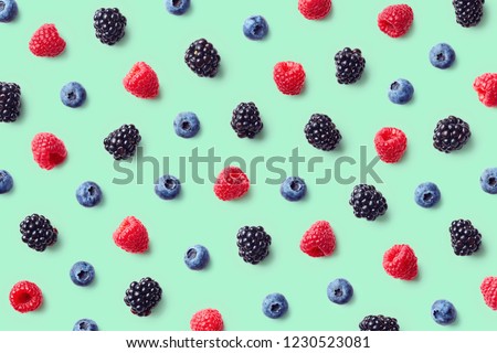 Colorful fruit pattern of wild berries on blue background. Raspberries, blueberries and blackberries. Top view. Flat lay