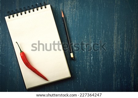 Blank recipe book and pencil on old dark blue wooden background