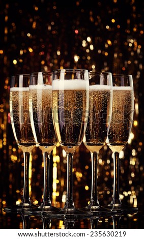 Five flutes of champagne on bokeh background