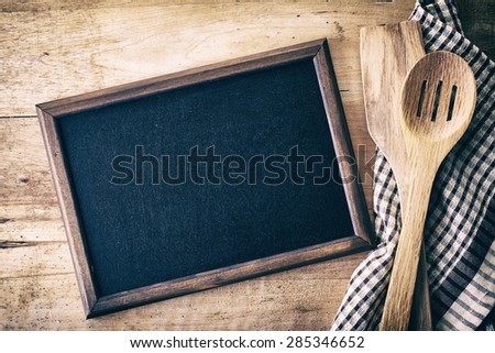 Blank blackboard on wooden surface and serving spoons