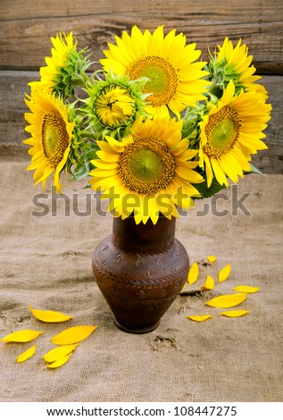 Bouquet of sunflowers in a clay vase.