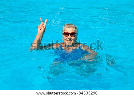 The old woman 70-75 years old, swims in the pool
