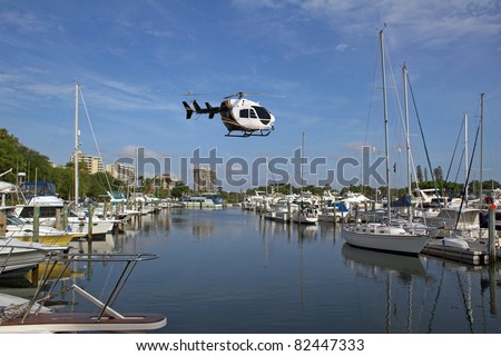 Helicopter bringing boat owner to his yacht dockside on ocean front