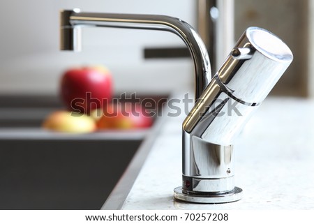 Stylish home interior sink tap and red apples