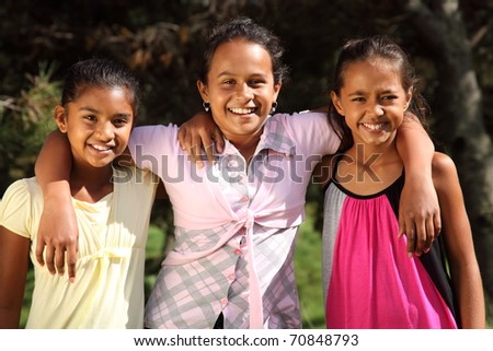 Friendship hug three happy smiling school girls