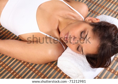 Beautiful woman lying in health spa head on towel