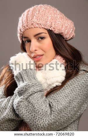 Young beauty keeping warm in winter woolly clothes