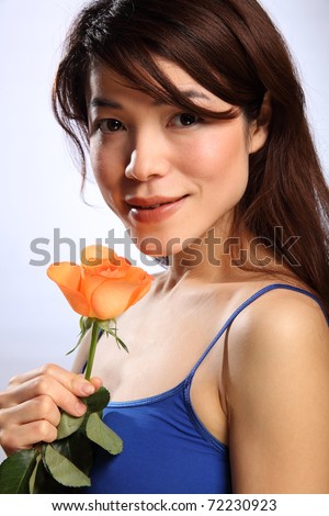 stock photo Beautiful young Japanese girl with orange rose