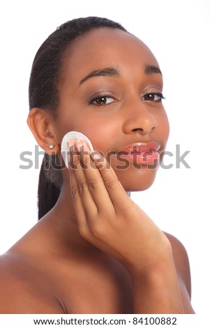Beautiful young african american woman using cosmetics cotton cleansing pad to remove make up from face.