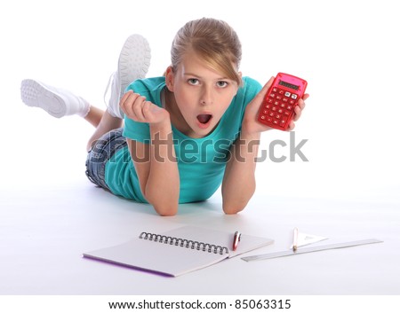 stock photo Young blonde primary school girl lying on floor doing math 
