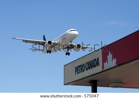 Air Canada jet flying over Petro-Canada gas station