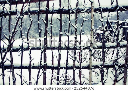 Lath fence around a farmer\'s house in Russia. Winter season