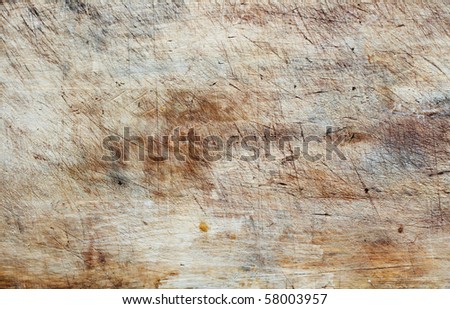 Closeup of a worn wooden cutting board, horizontal composition.
