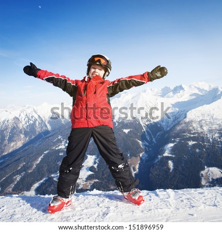 Child wearing ski clothes having fun in mountains