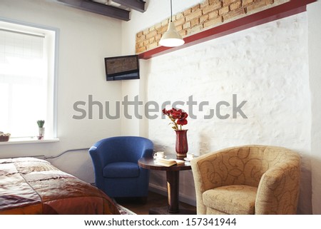 The interior of a cozy studio-type guest house, armchairs ant TV set