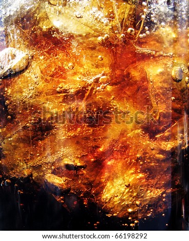 Closeup of fresh brown splashing liquid - cola or other drink with ice and air bubbles