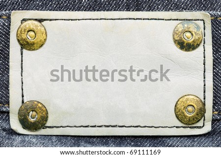 Frame for your text - closeup of blank white grungy artificial leather label with yellow metal rivets