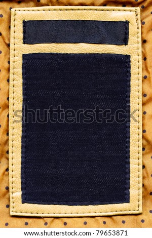 Big size blank grungy combined artificial leather and dark cotton and jeans label on yellow dotted textile background