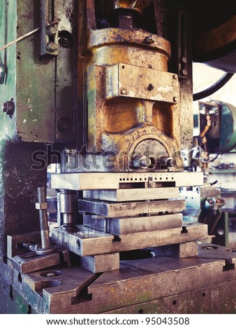 An old factory interior and an obsolete heavy machinery for metal works