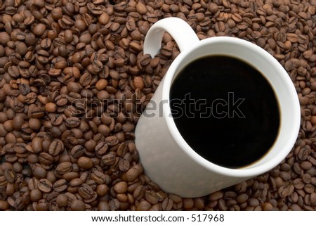 Cup of coffee in a sea of coffee beans