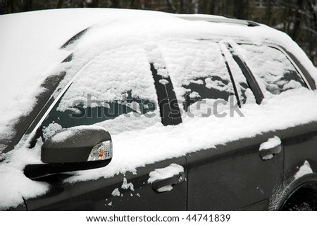 snowy grey car with mirror,  horizontally framed picture