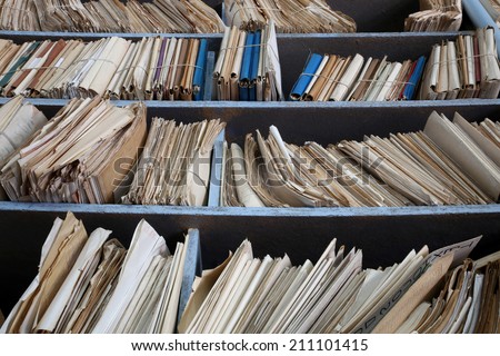 shelves full of files in a messy old-fashioned archive
