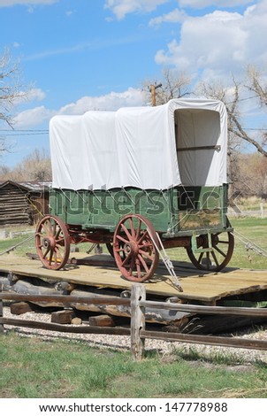 Vintage covered wagon displayed outdoors.