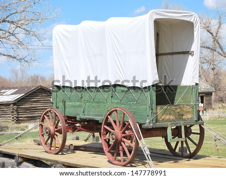 Vintage covered wagon displayed outdoors.