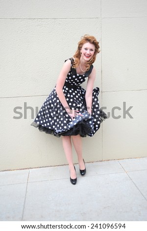 Female fashion model dress blowing in the wind outside.