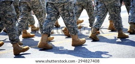 Military boots on the ground in a holiday parade outdoors.