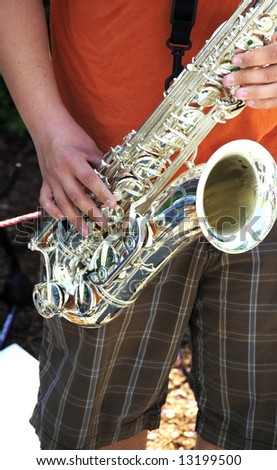 Jazz saxophone player playing a solo at a concert outdoors.